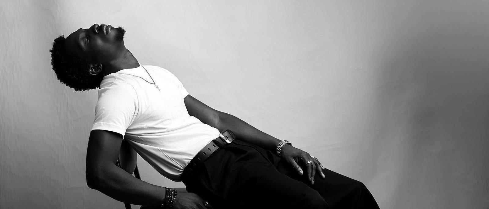 Wide frame of Greatman Takit reclined back over a chair.